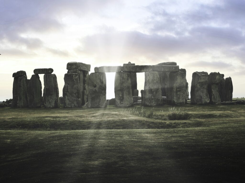 A group of stonehenge standing in a field A group of stonehenge standing in a field