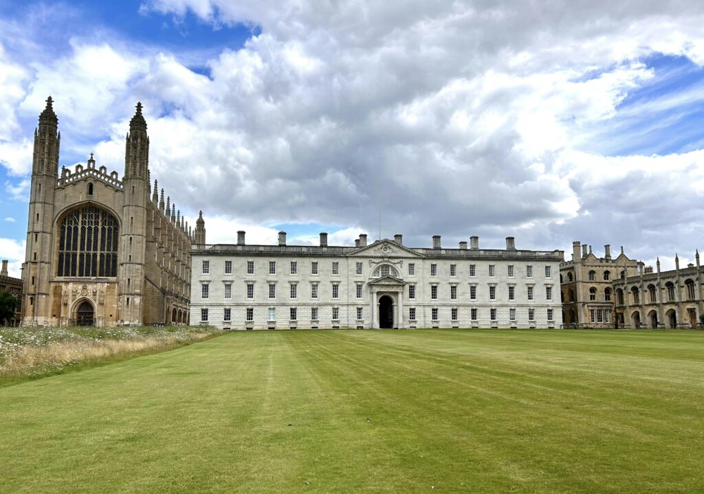 A large building sitting on top of a lush green field A large building sitting on top of a lush green field