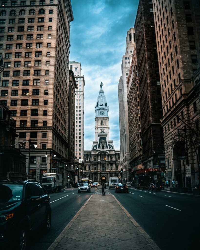 a city street with tall buildings and a clock tower a city street with tall buildings and a clock tower