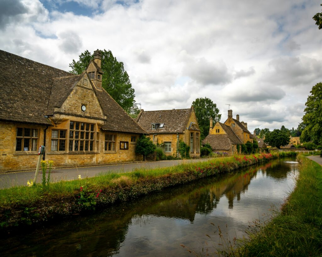 brown and gray house beside river under cloudy sky during daytime brown and gray house beside river under cloudy sky during daytime