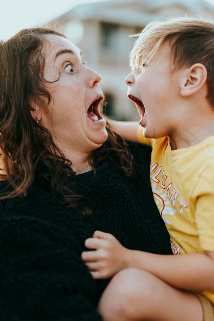 woman in black sweater kissing girl in yellow shirt woman in black sweater kissing girl in yellow shirt