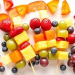 Rainbow fruit kabobs with various colorful fruits arranged in rainbow order on wooden skewers