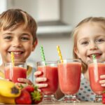 Two children enjoying colorful fruit smoothies with straws